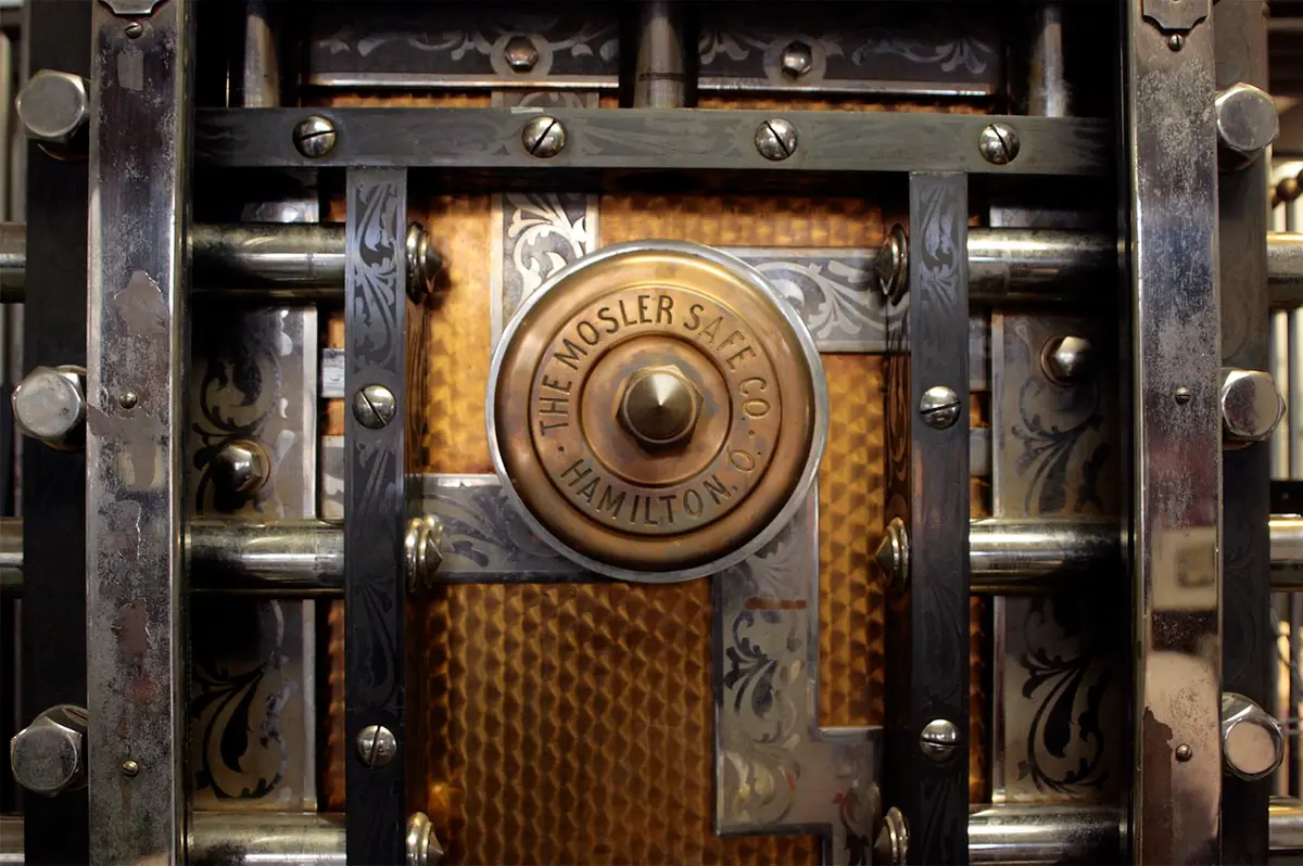 Antique bank vault door with a brass combination dial, representing institutional custody